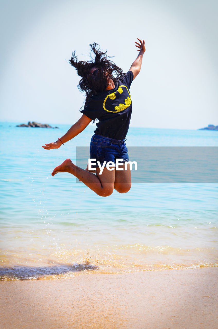 Woman jumping on beach