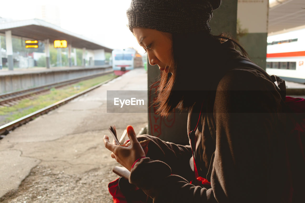 SIDE VIEW OF WOMAN ON RAILROAD TRACK