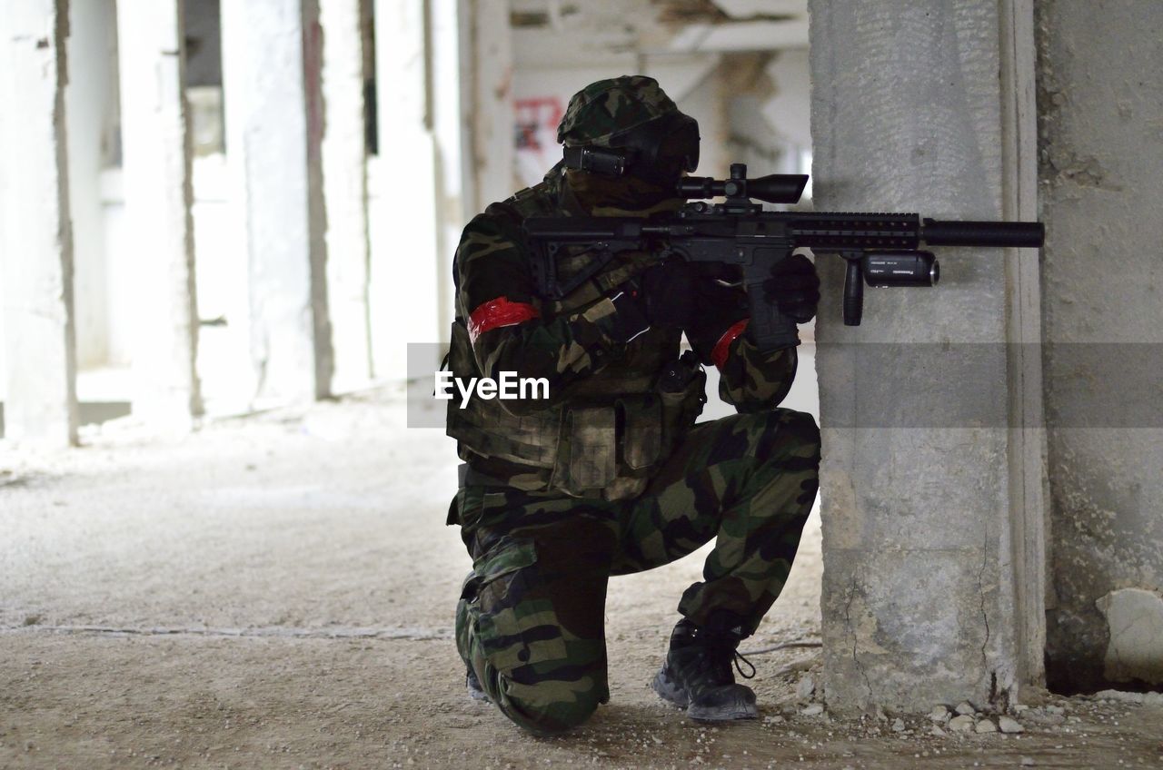 Army solider with machine gun in abandoned building