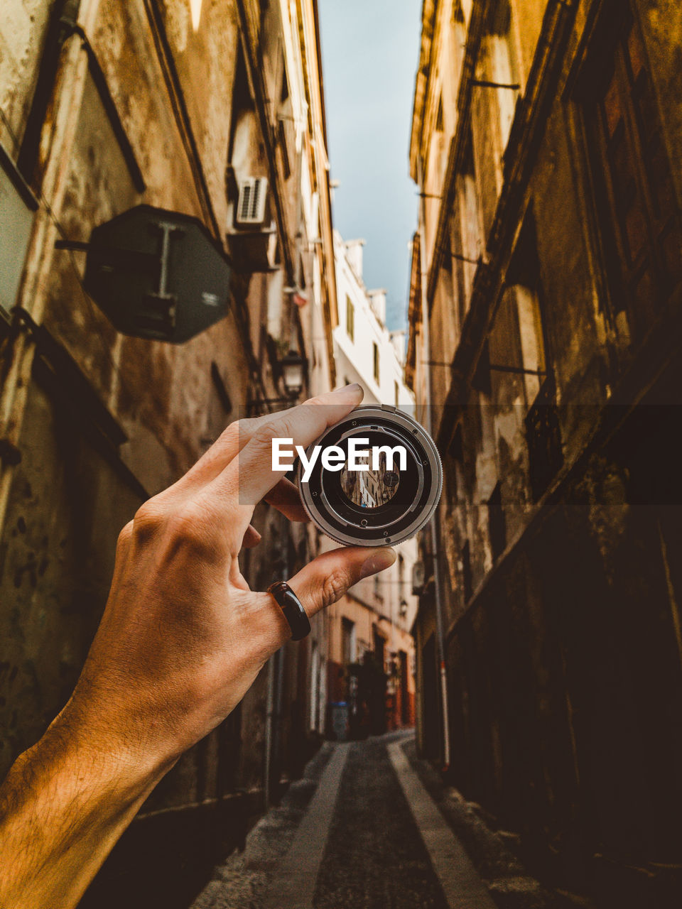 Midsection of man holding camera against sky