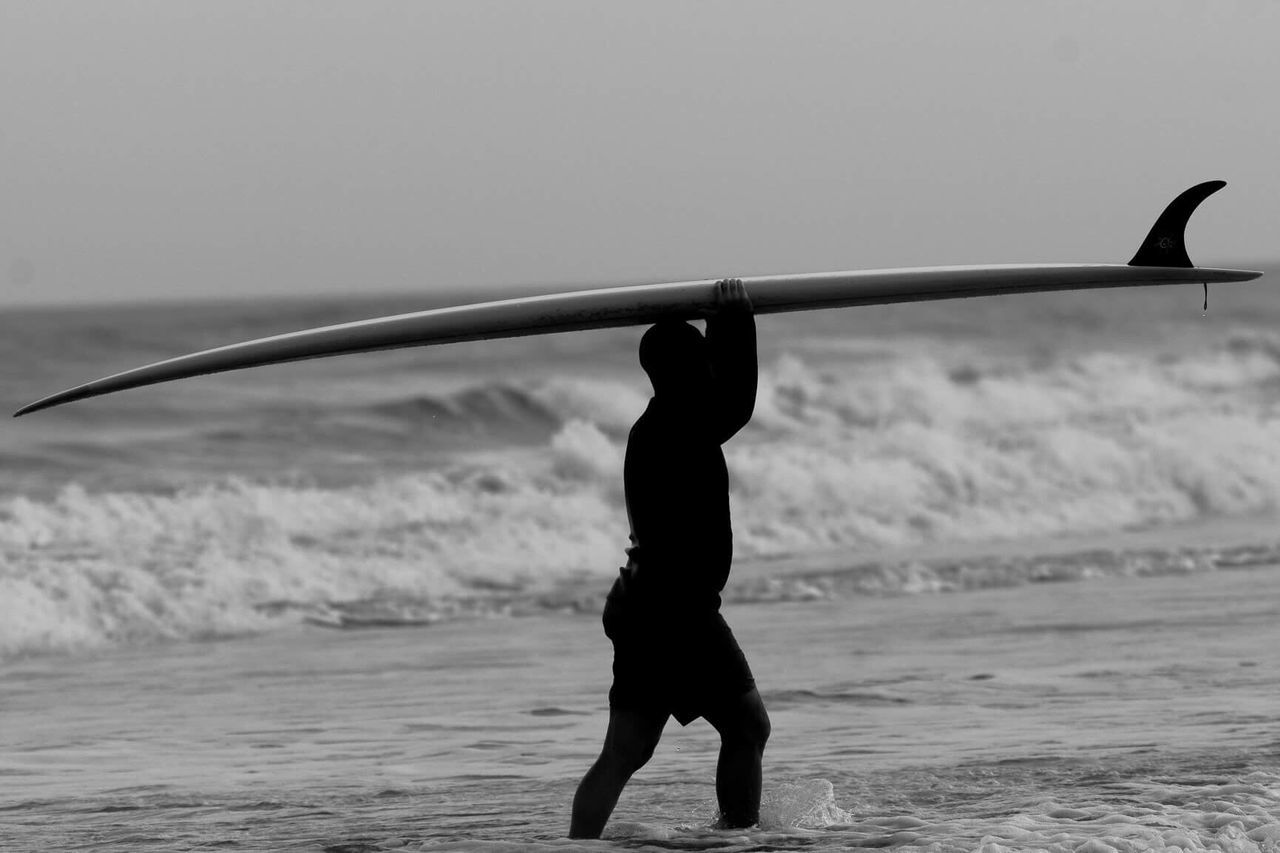 Surfer carrying surfboard