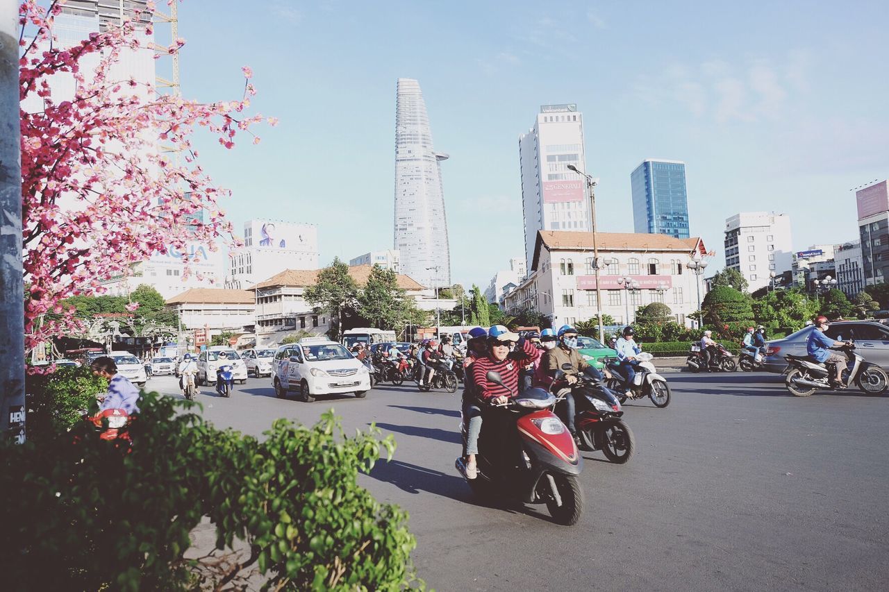 VEHICLES ON ROAD AGAINST BUILDINGS IN CITY