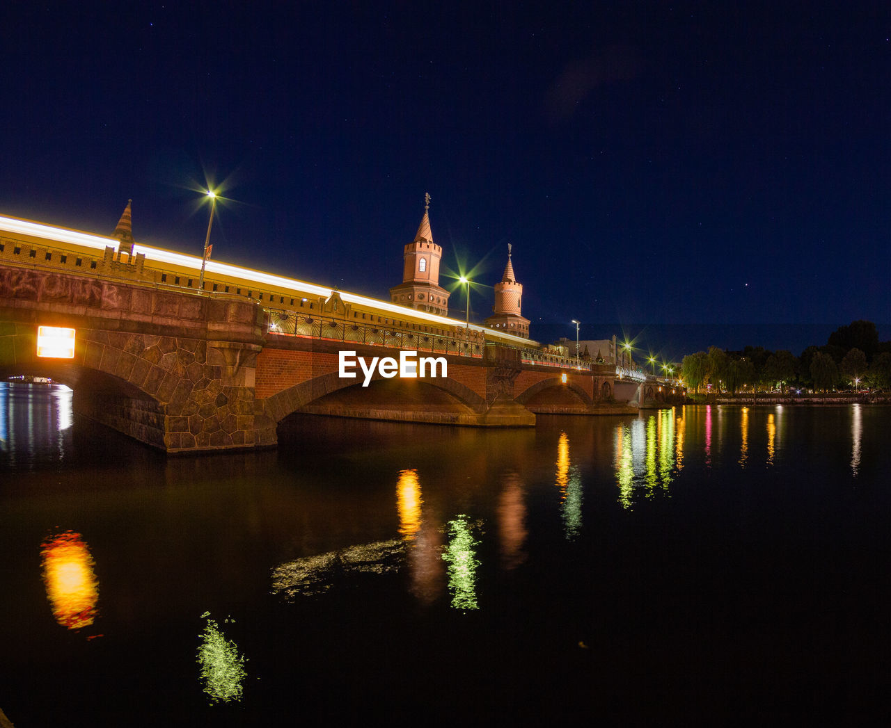 Illuminated bridge over river at night