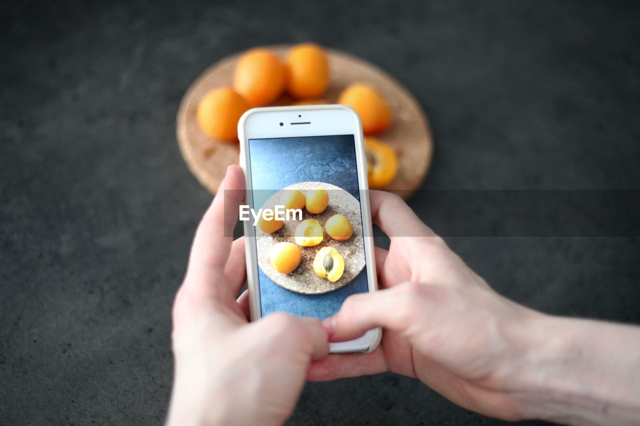 HIGH ANGLE VIEW OF PERSON HAND HOLDING FRUITS