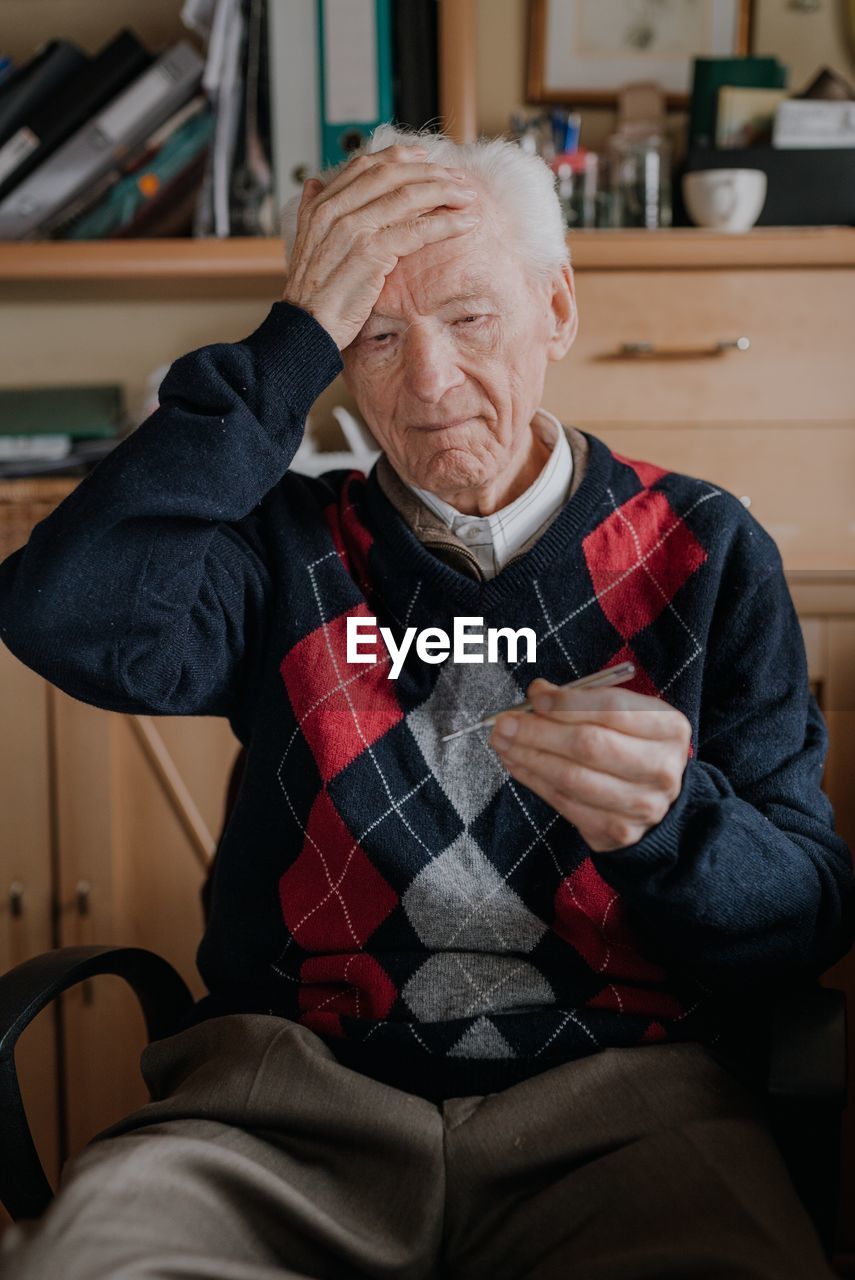 Midsection of man sitting at home