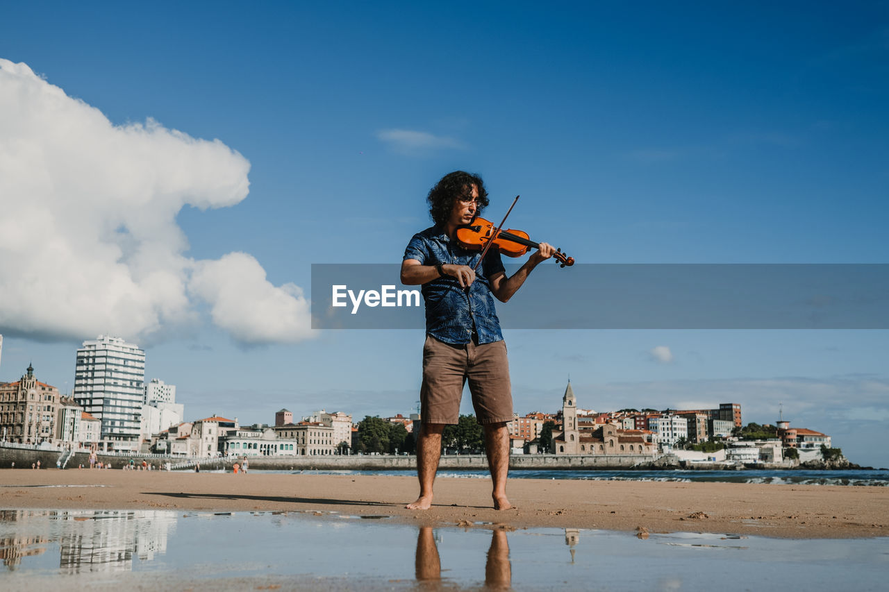 Man standing by sea against sky