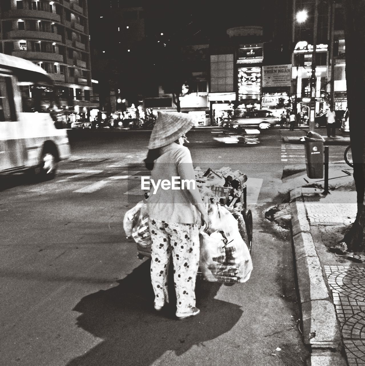 Rear view of woman with cart on city street