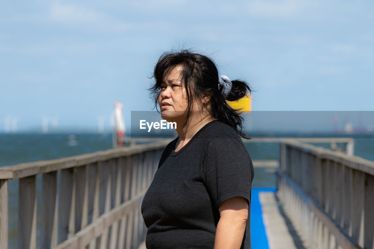 An asian middle aged woman on a jetty 