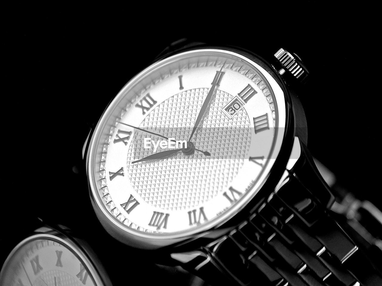 Close-up of wristwatch against black background