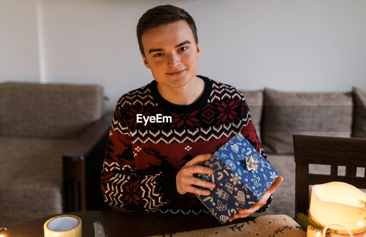 Young man holding a carefully wrapped christmas present