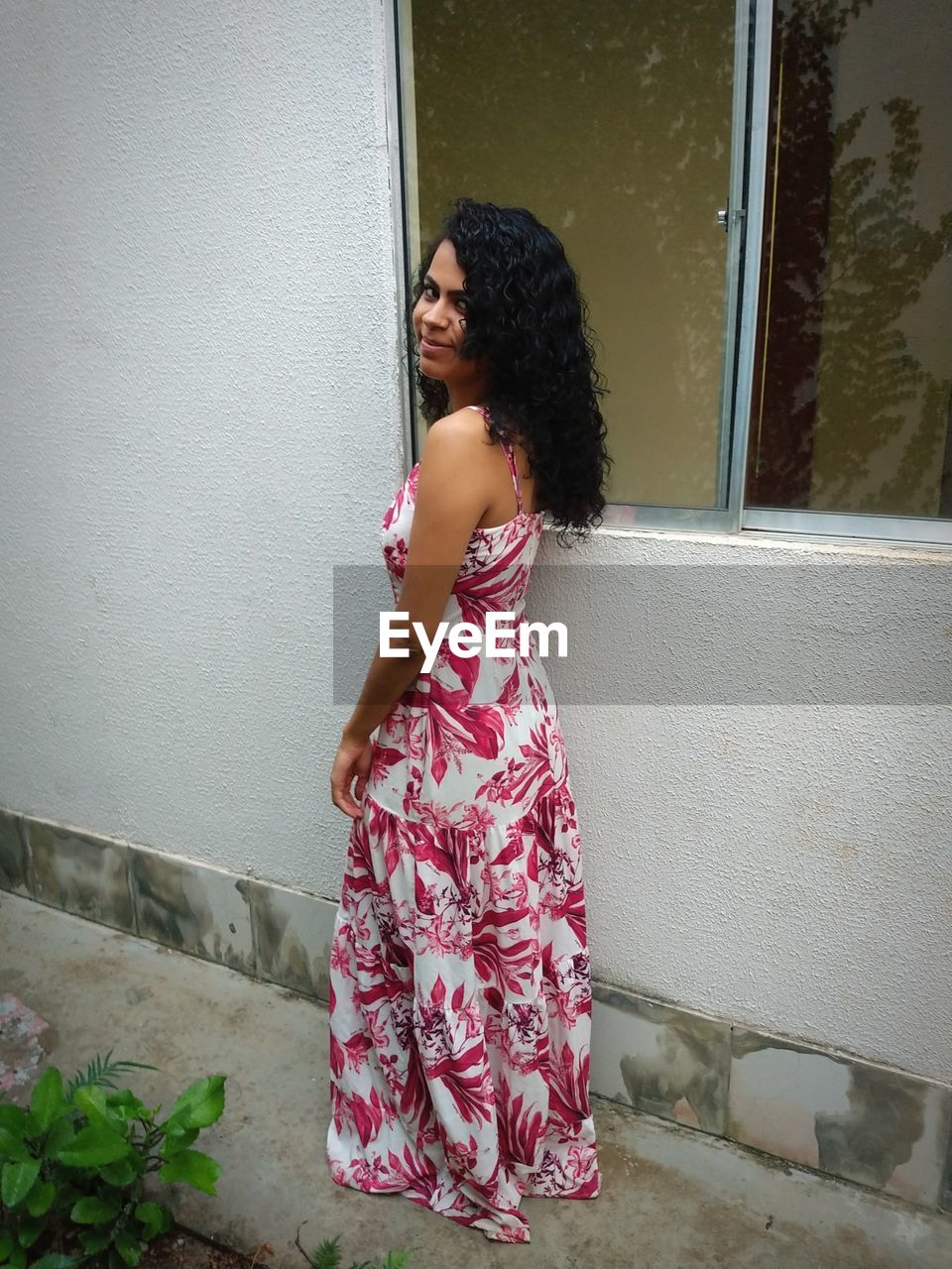 Portrait of woman standing by wall outdoors