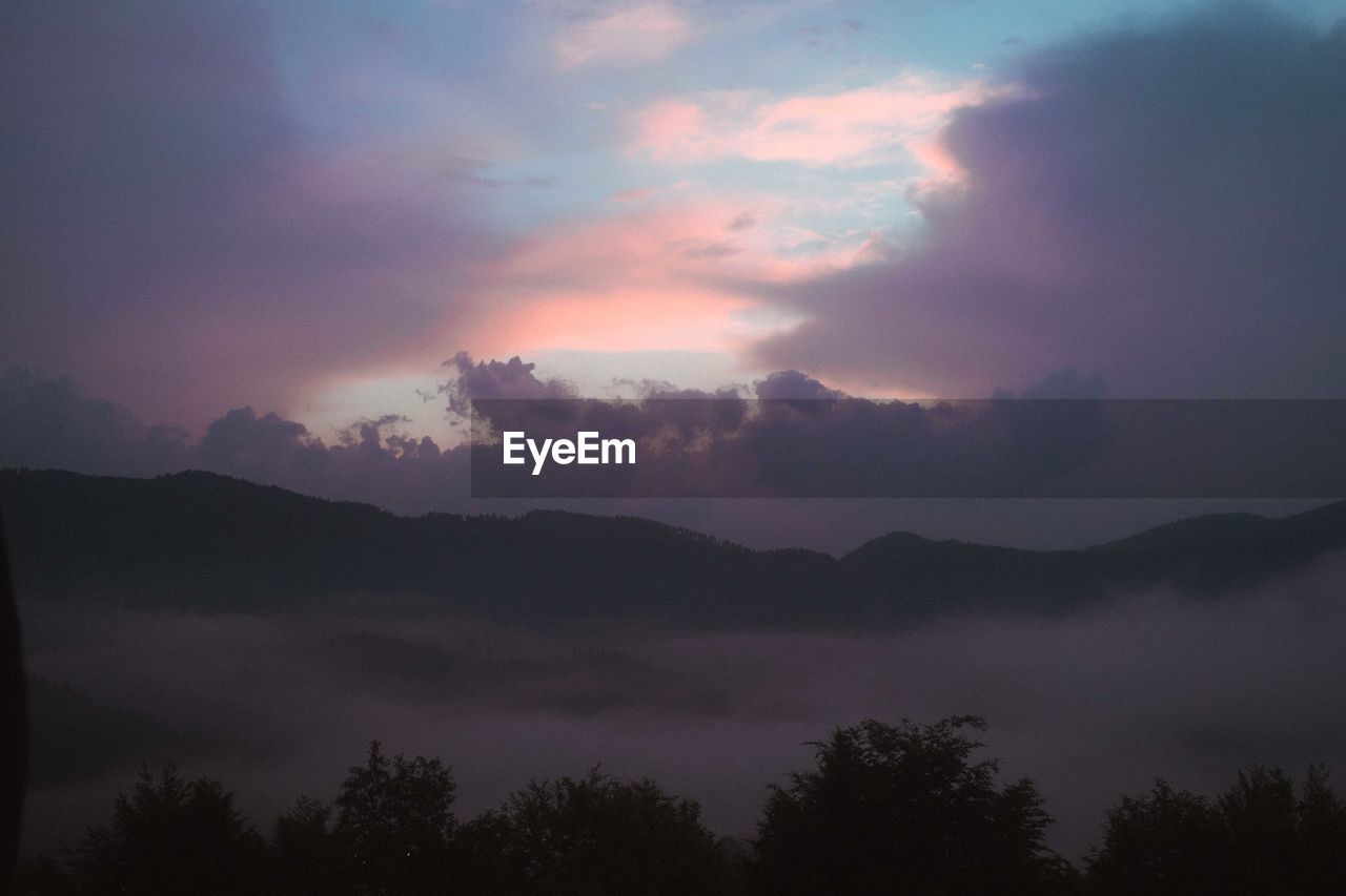 SCENIC VIEW OF DRAMATIC SKY OVER SILHOUETTE MOUNTAINS