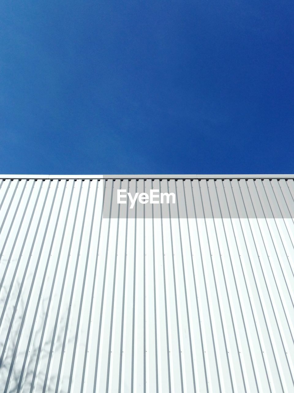 Low angle view of white building against clear blue sky