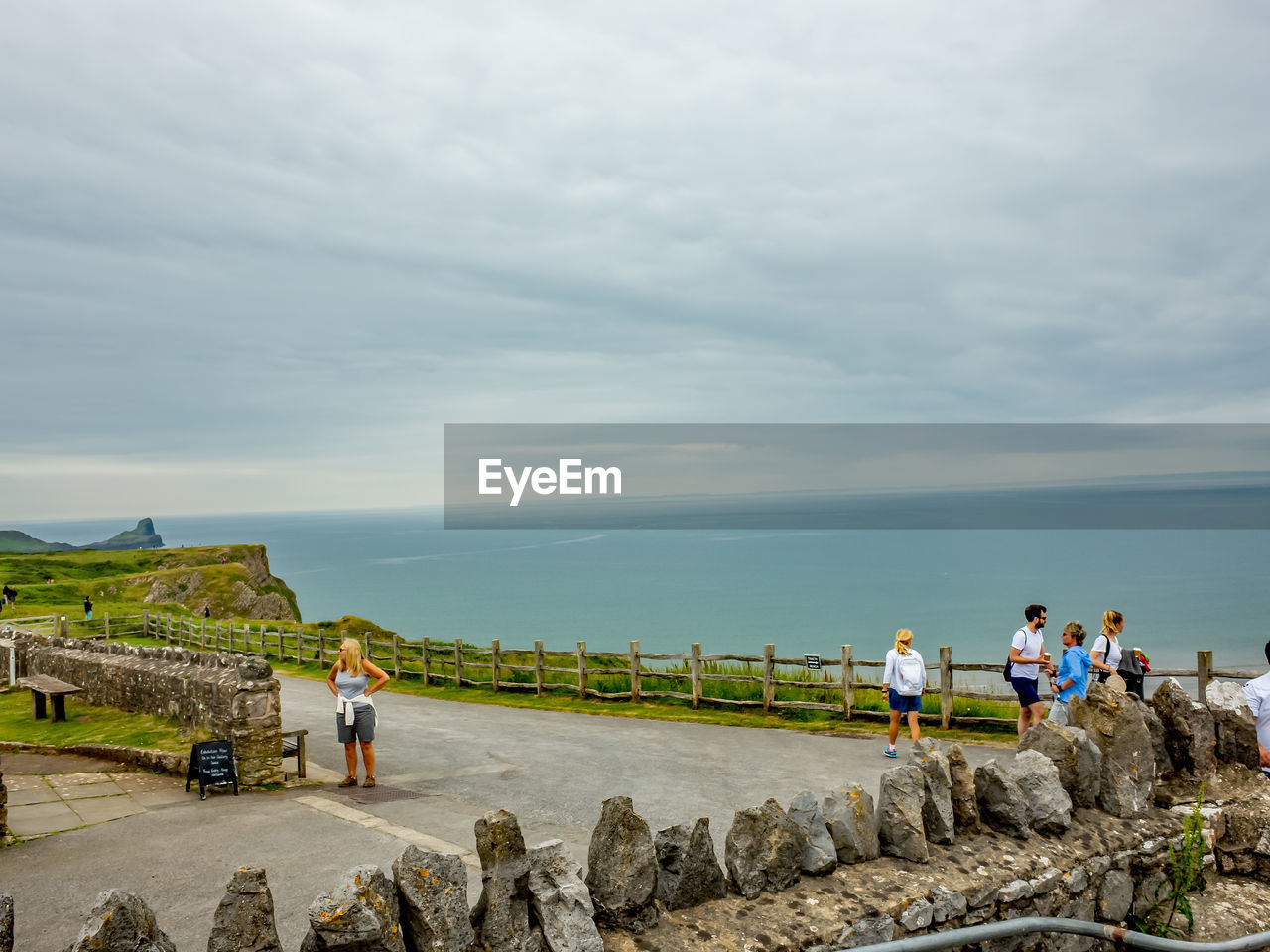 GROUP OF PEOPLE ON THE SEA SHORE AGAINST SKY