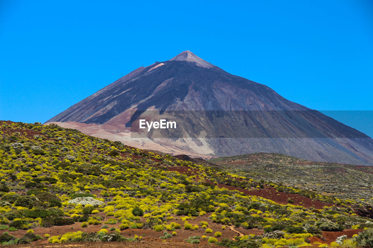 Scenic view of mountains against clear blue sky