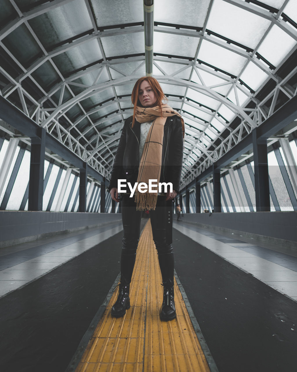 Portrait of young woman standing on footbridge