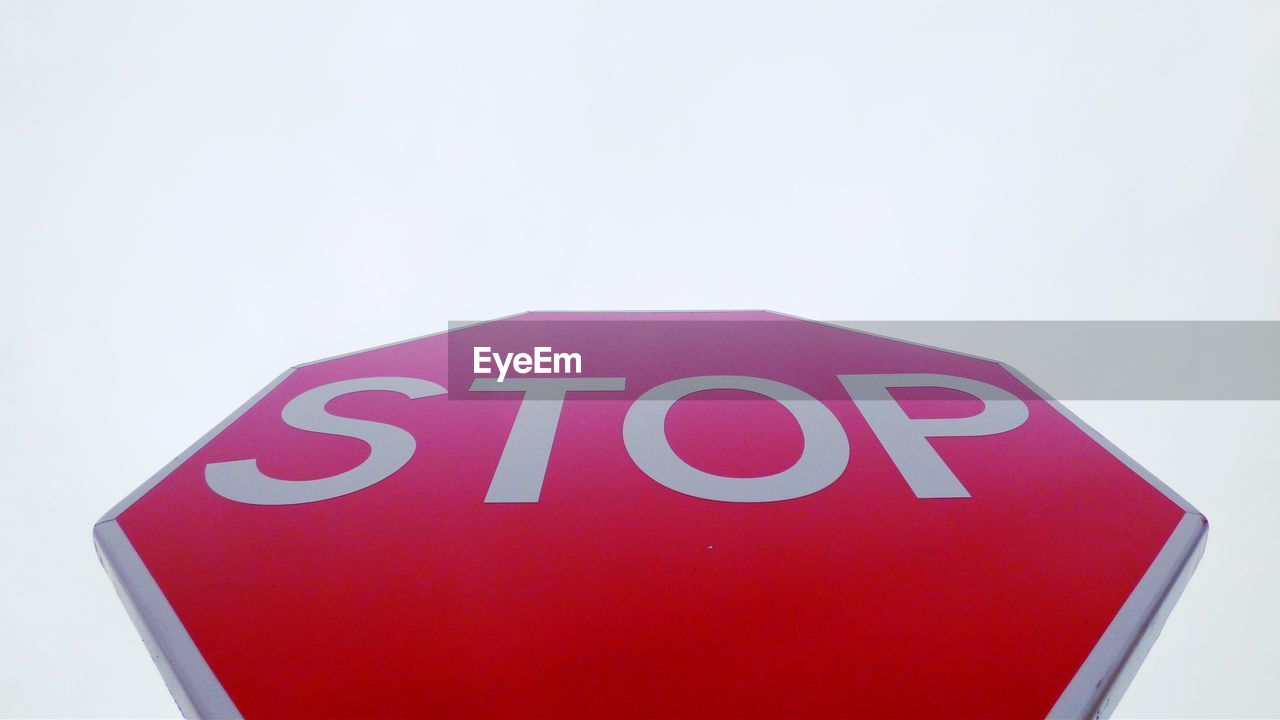 Low angle view of stop sign against clear sky
