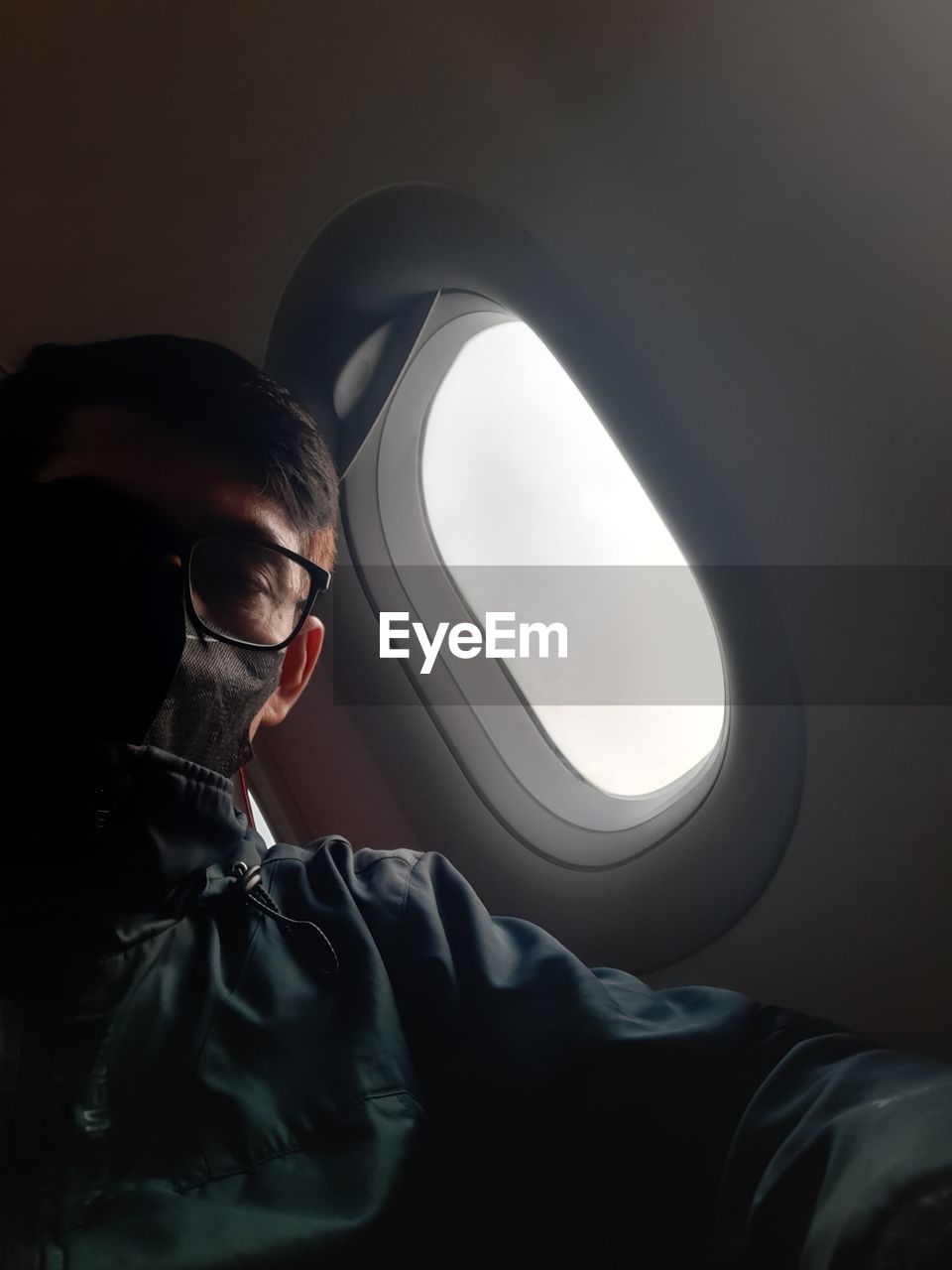 darkness, light, one person, mode of transportation, transportation, black, adult, air vehicle, airplane, indoors, travel, vehicle interior, journey, portrait, screenshot, person, young adult