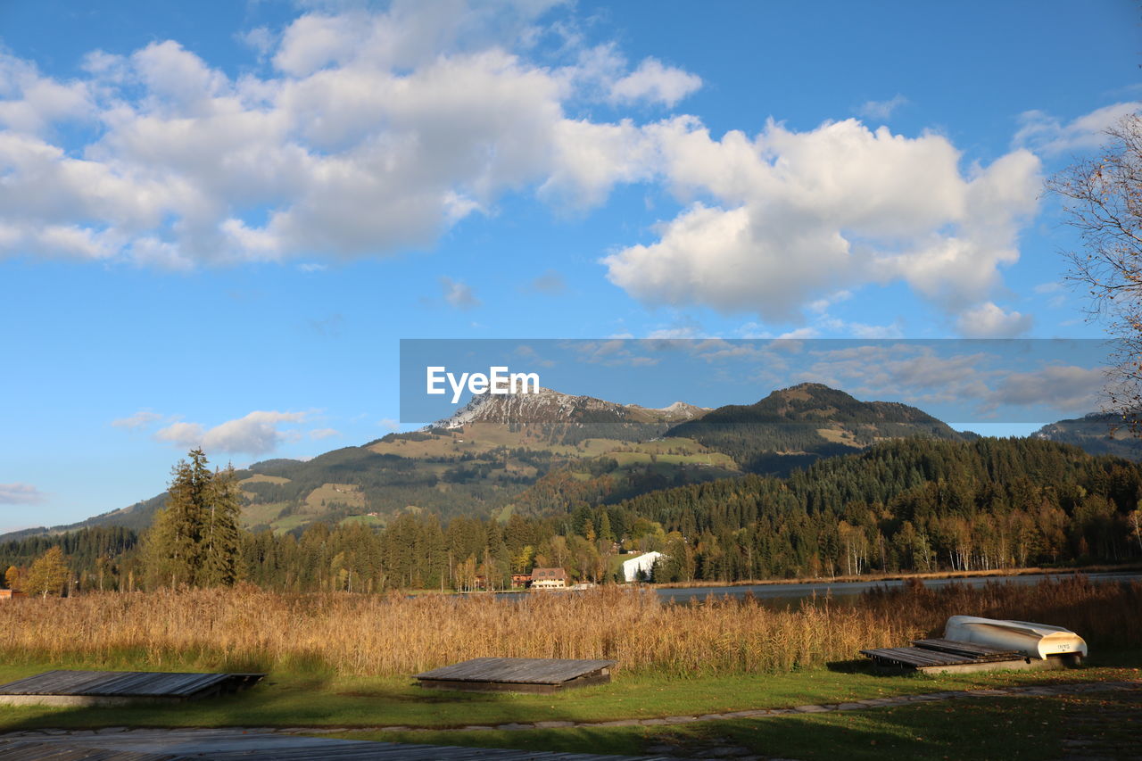 Scenic view of lake by mountains against sky