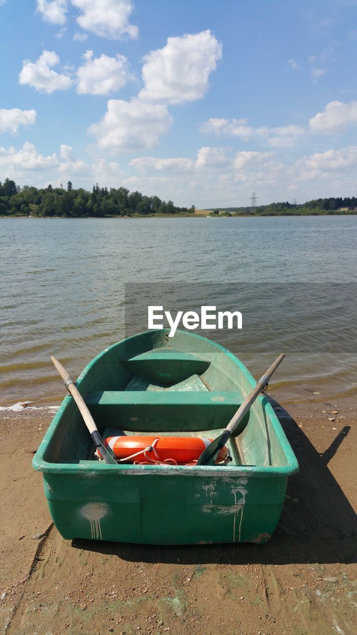 Boat moored in lake against sky