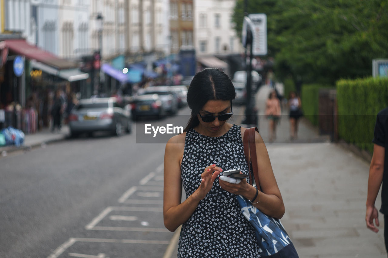 WOMAN USING SMART PHONE ON STREET