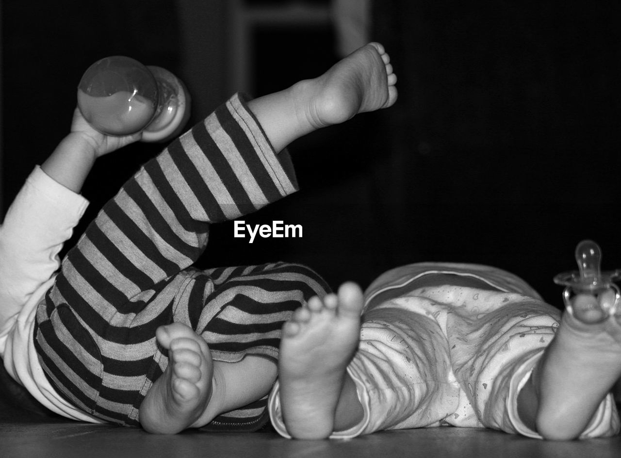 Close-up of babies lying on bed