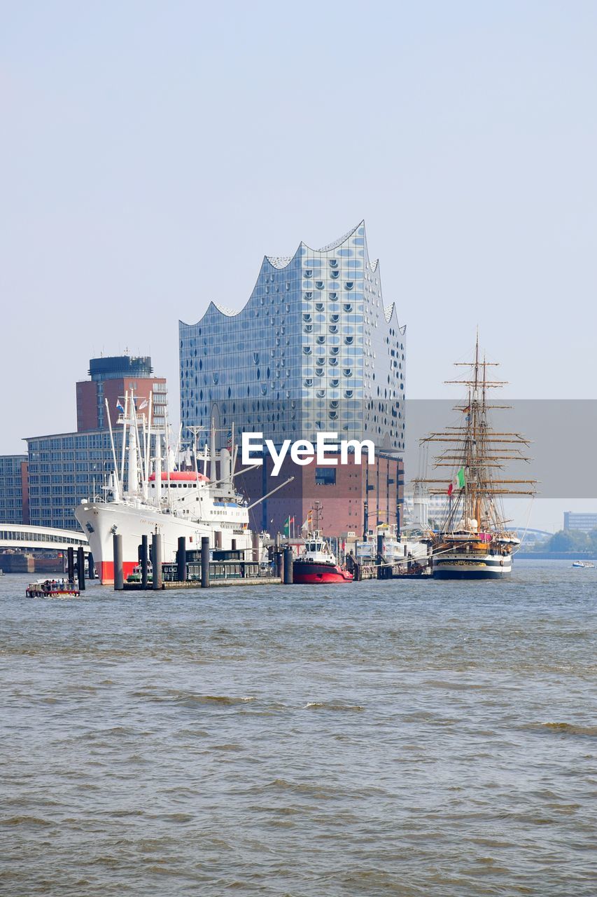 Boats in sea against buildings in city