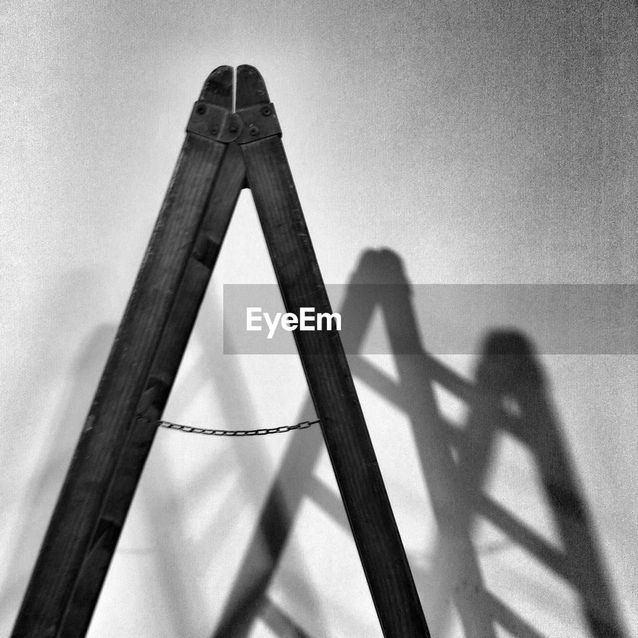 Wooden step ladder with shadow against wall