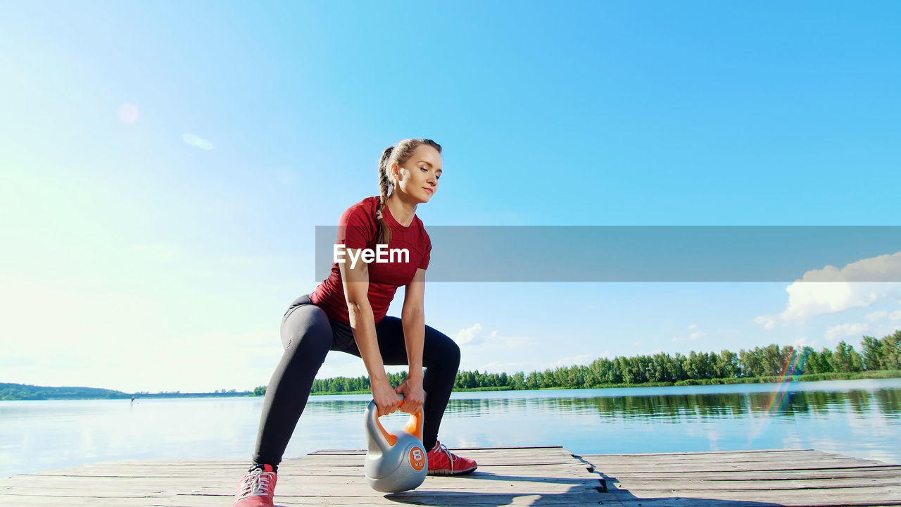 Beautiful, athletic young blond woman doing different exercises with weights, dumbbells, lunges