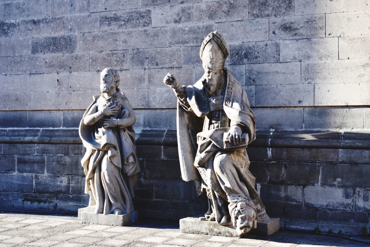 STATUE OF MAN STANDING ON THE WALL