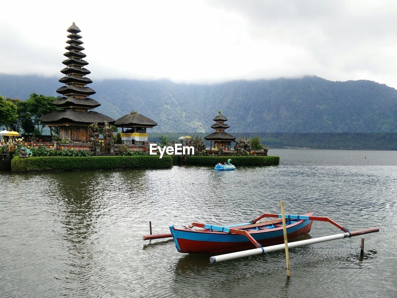 Built structure in a lake with a temple in the background