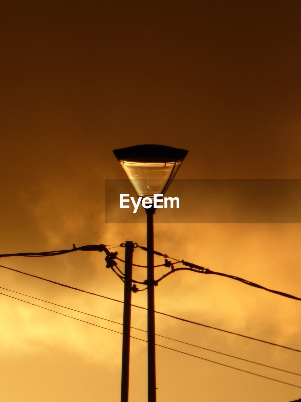 Low angle view of street light against orange sky