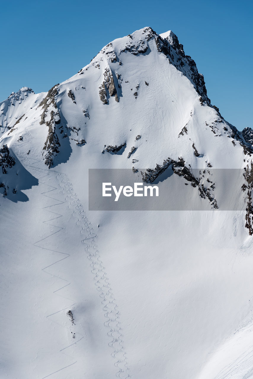 SNOW COVERED MOUNTAINS AGAINST SKY