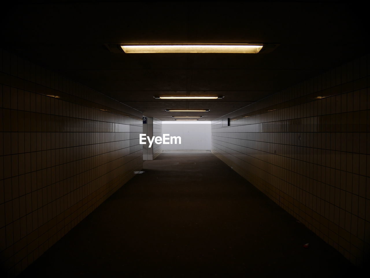 EMPTY CORRIDOR IN ILLUMINATED ROOM