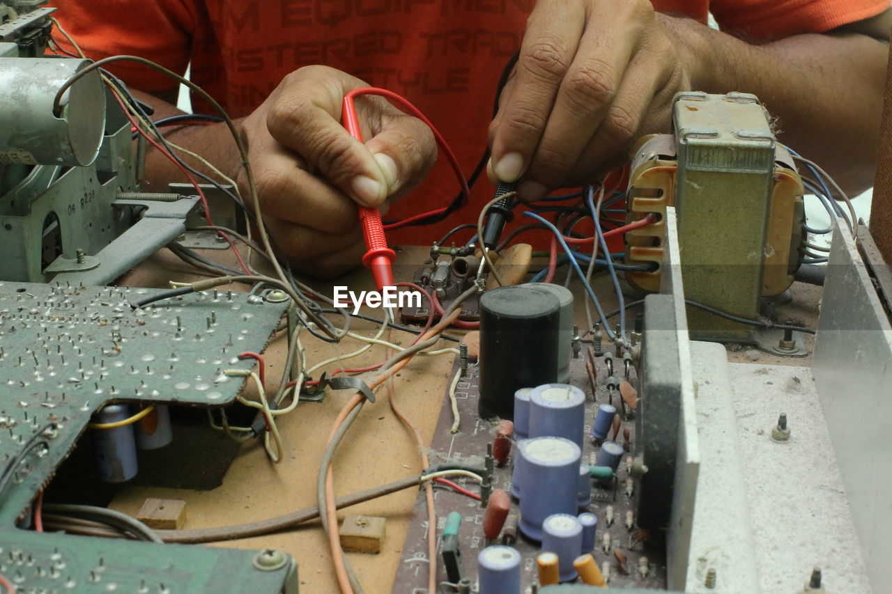 Cropped hands of male technician repairing radio