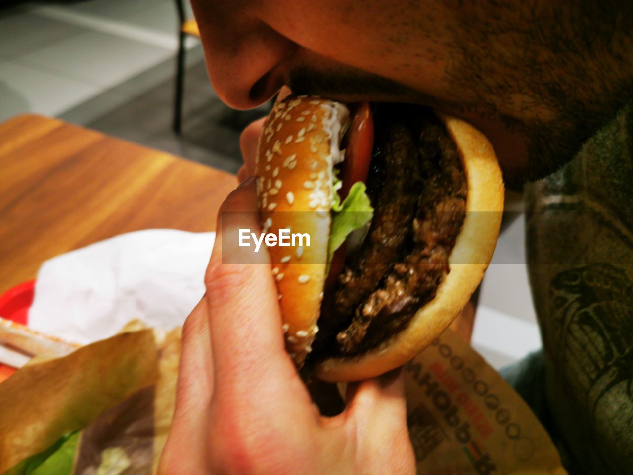 Midsection of person holding cheese burger 