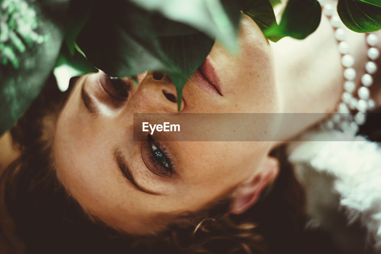 Close-up portrait of woman by plants