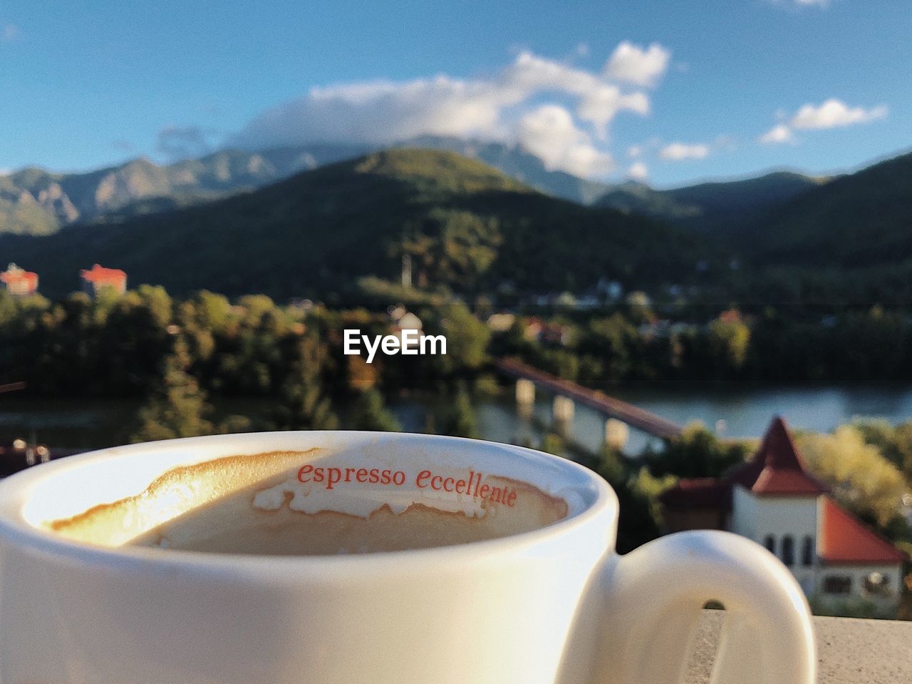 Close-up of coffee cup against mountains