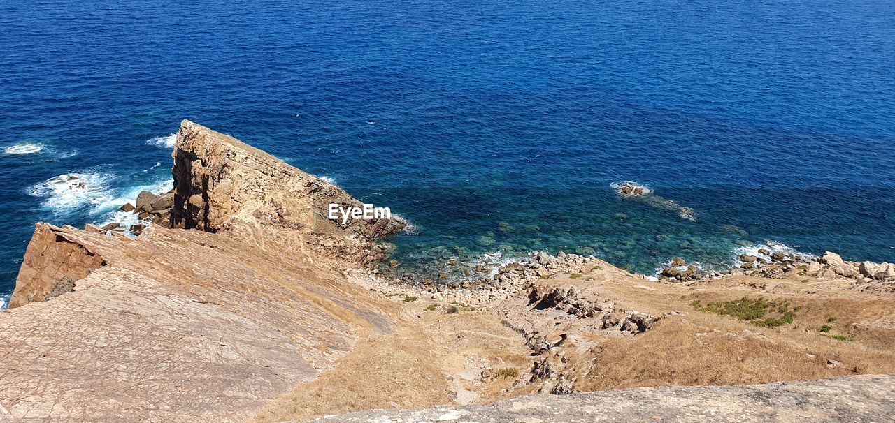 HIGH ANGLE VIEW OF ROCKS ON SHORE