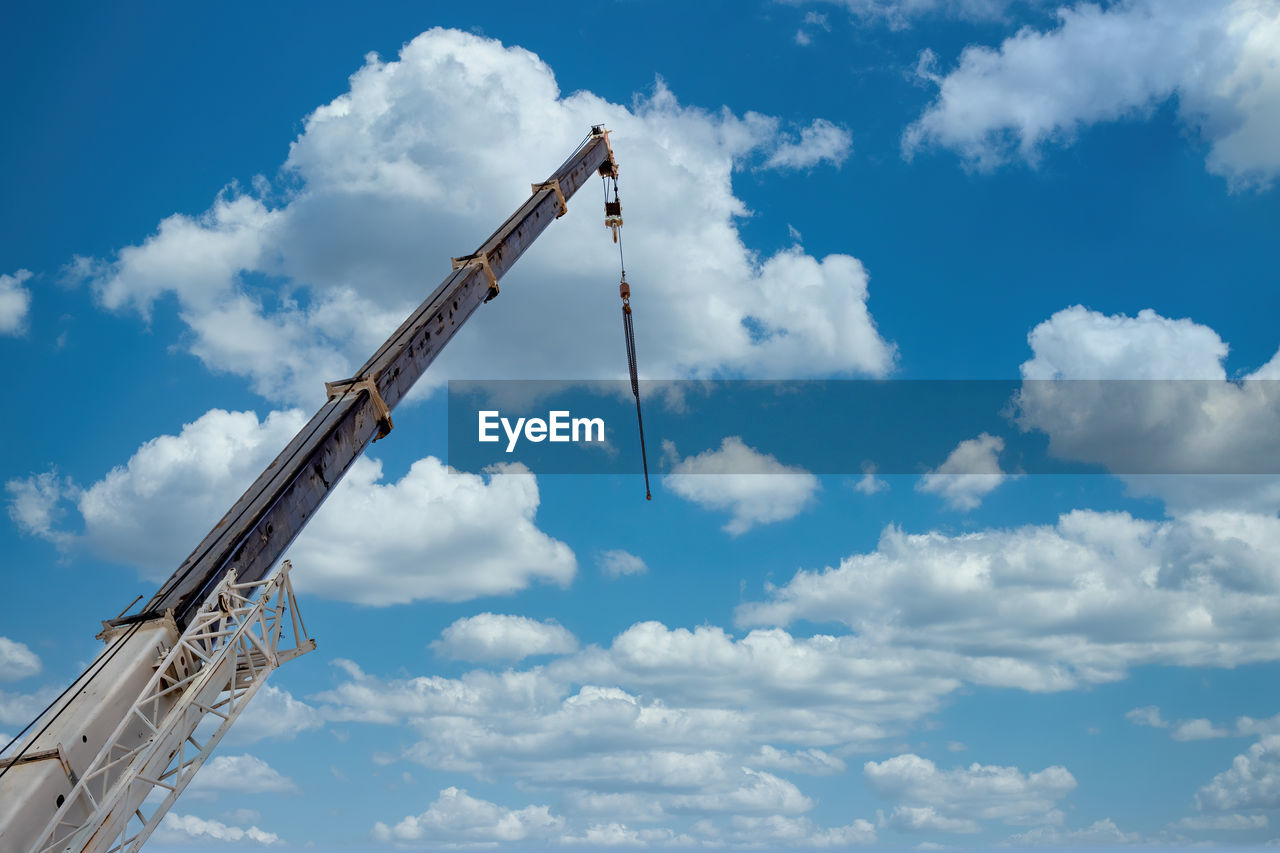 Low angle view of crane against sky