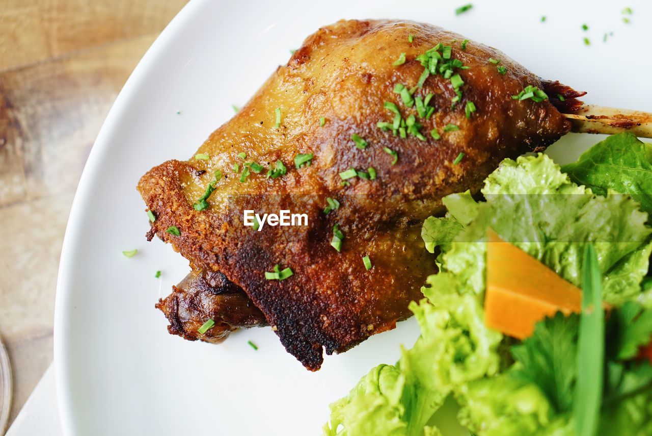 Close-up of vegetables and fried chicken in plate