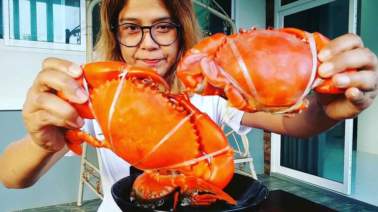 Woman holding tied crabs