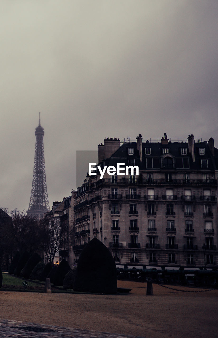 Buildings in city against cloudy sky