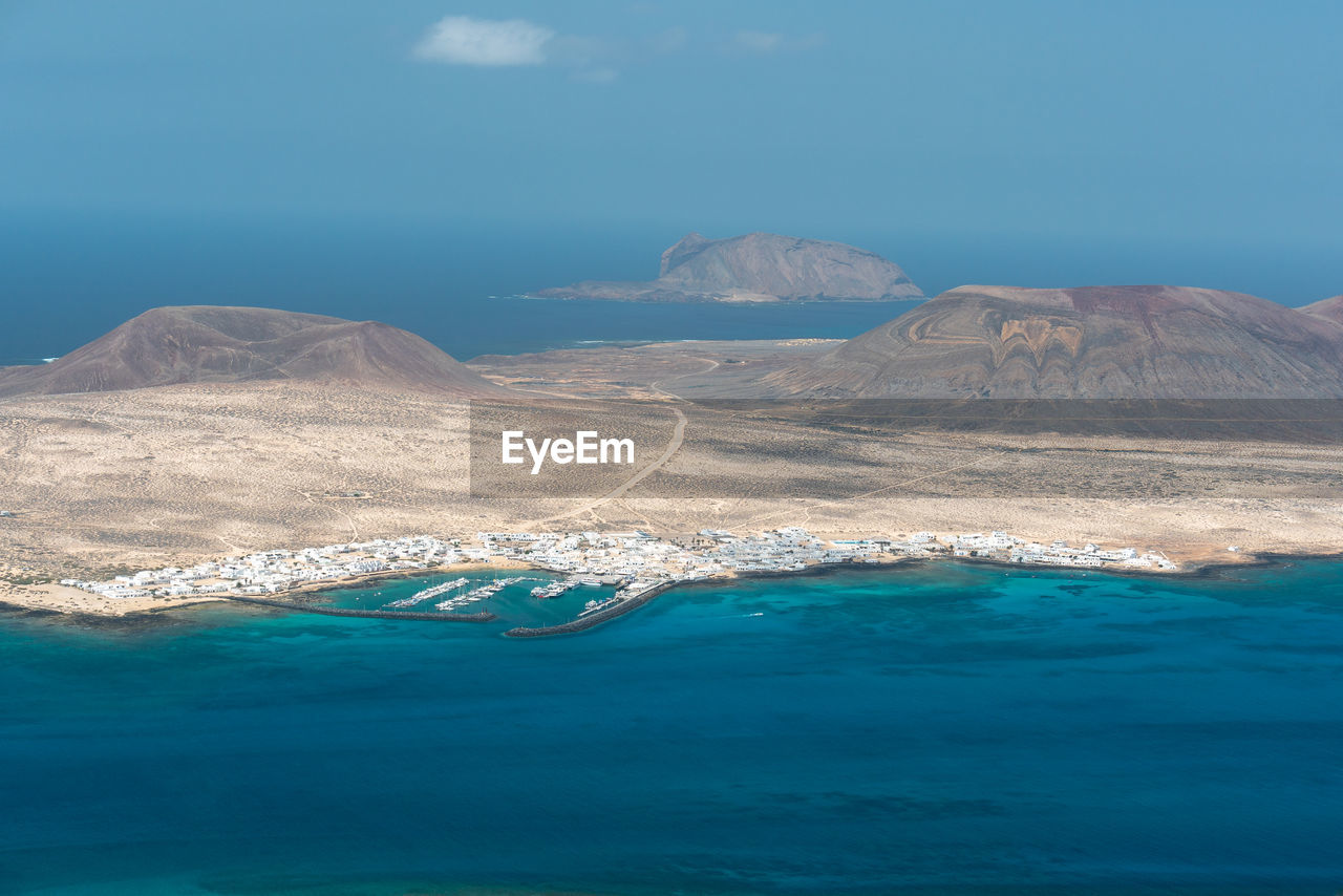 Aerial view of sea and mountain against sky