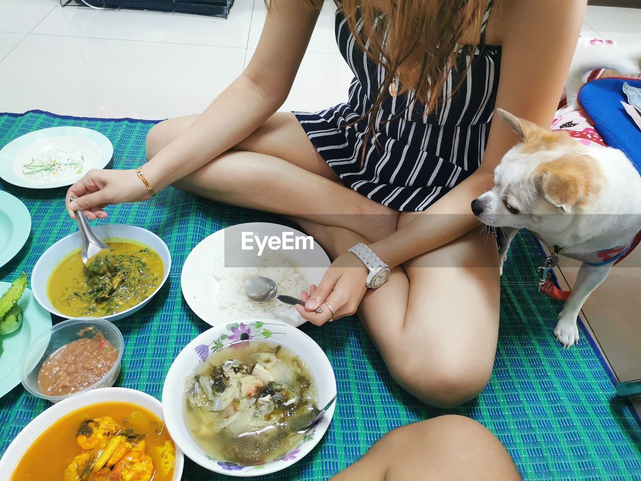 MIDSECTION OF WOMAN SITTING BY FOOD