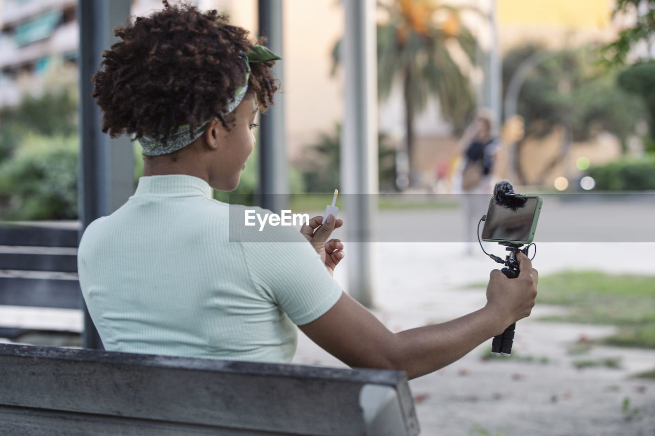 Afro young man streaming makeup tips for his followers on social media.