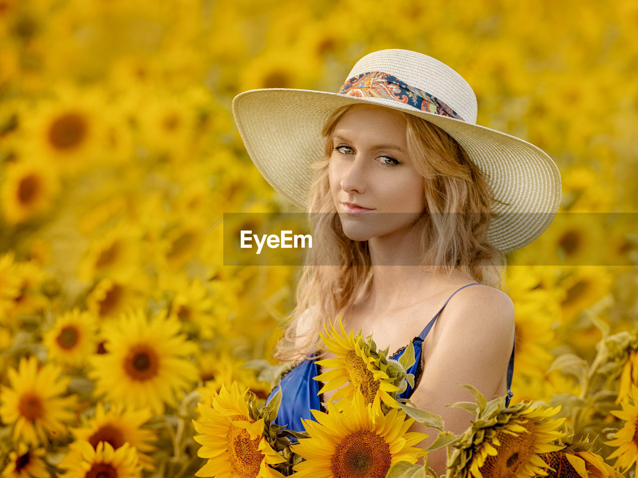 Portrait of beautiful woman amidst sunflowers