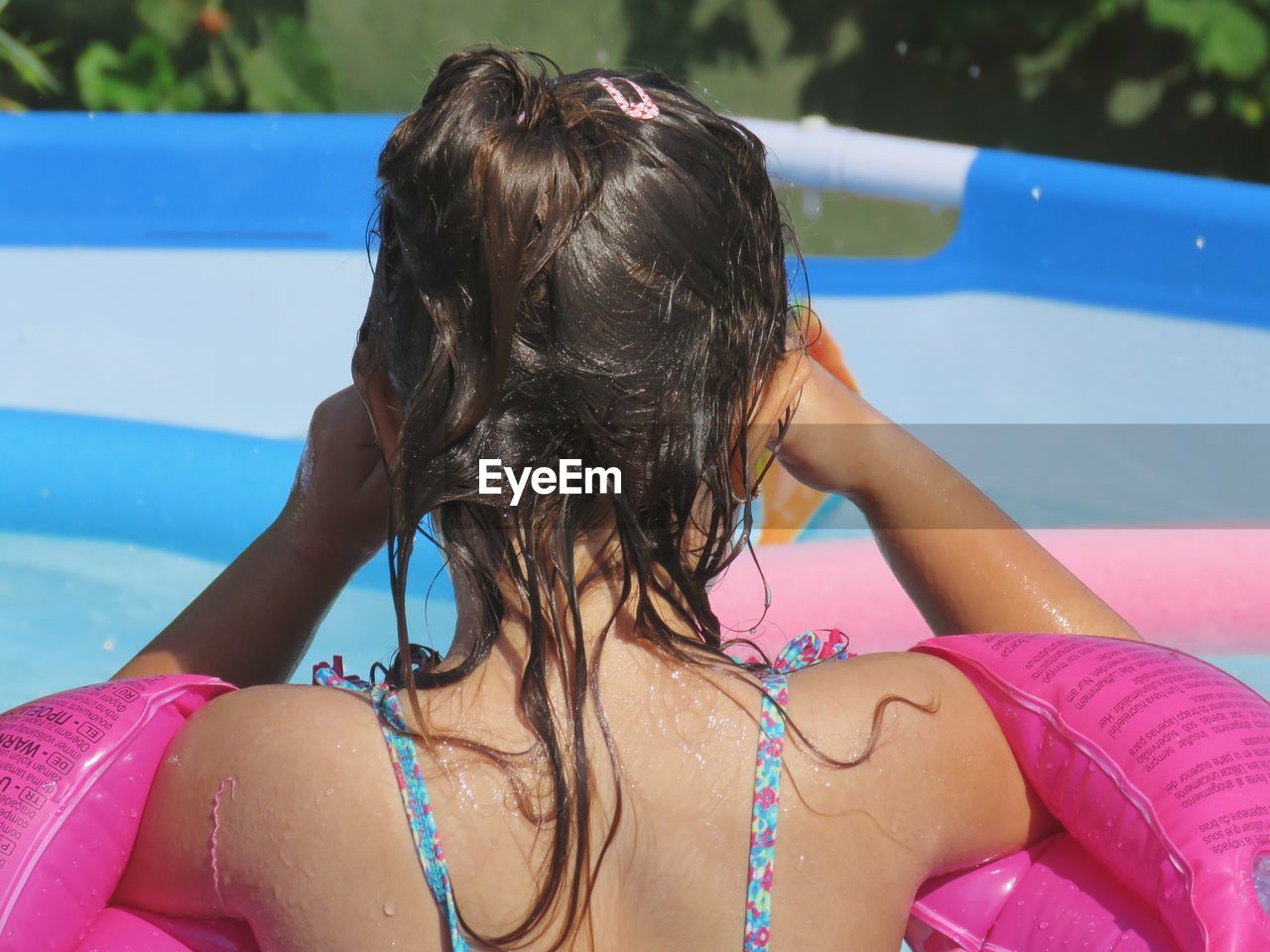 Rear view of girl in wading pool