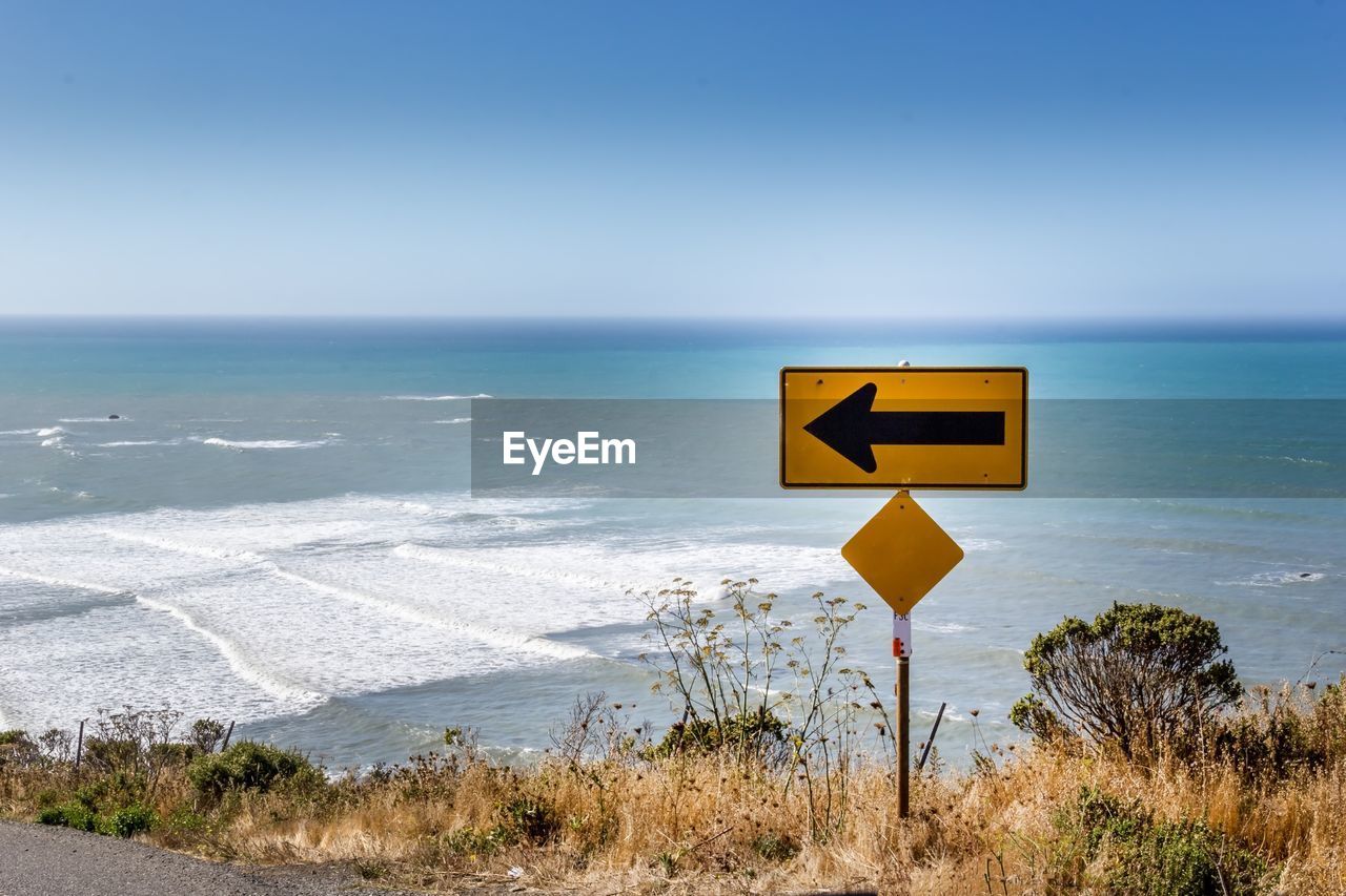 INFORMATION SIGN ON BEACH AGAINST SKY