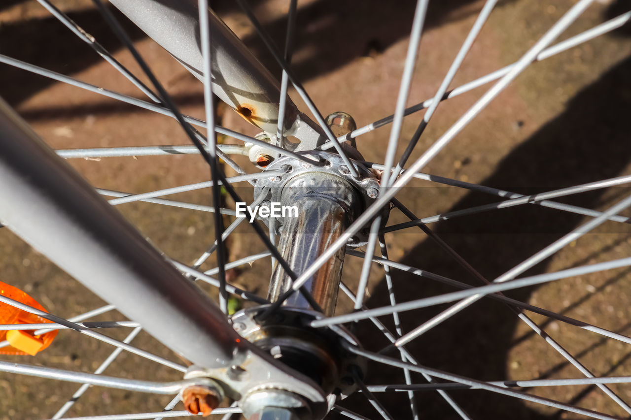 Selective focus close up view at a bicycle wheel with metal spokes
